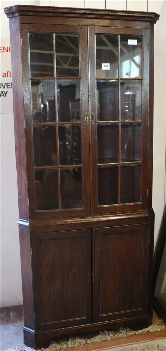 An early 19th century oak standing corner cupboard